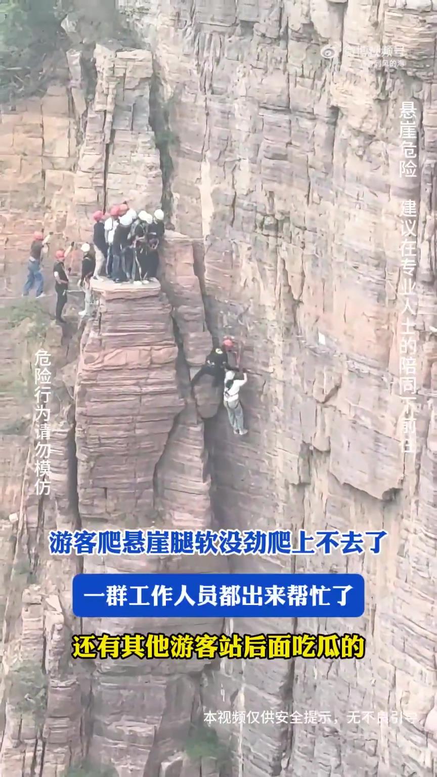 游客爬悬崖腿软没劲爬上不去了，一群工作人员都出来帮忙了！