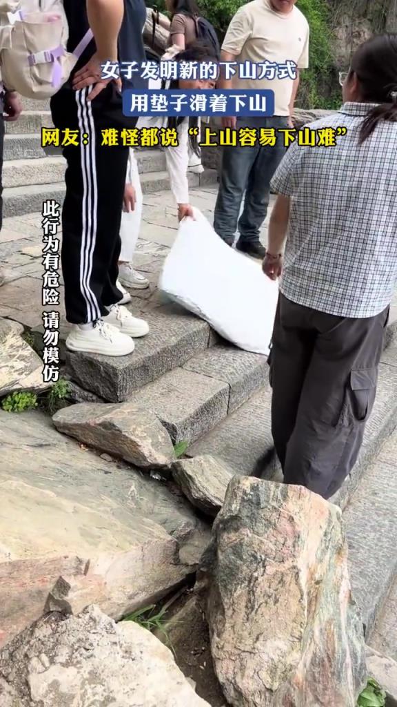 女子发明新的下山方式，用垫子滑着下山！