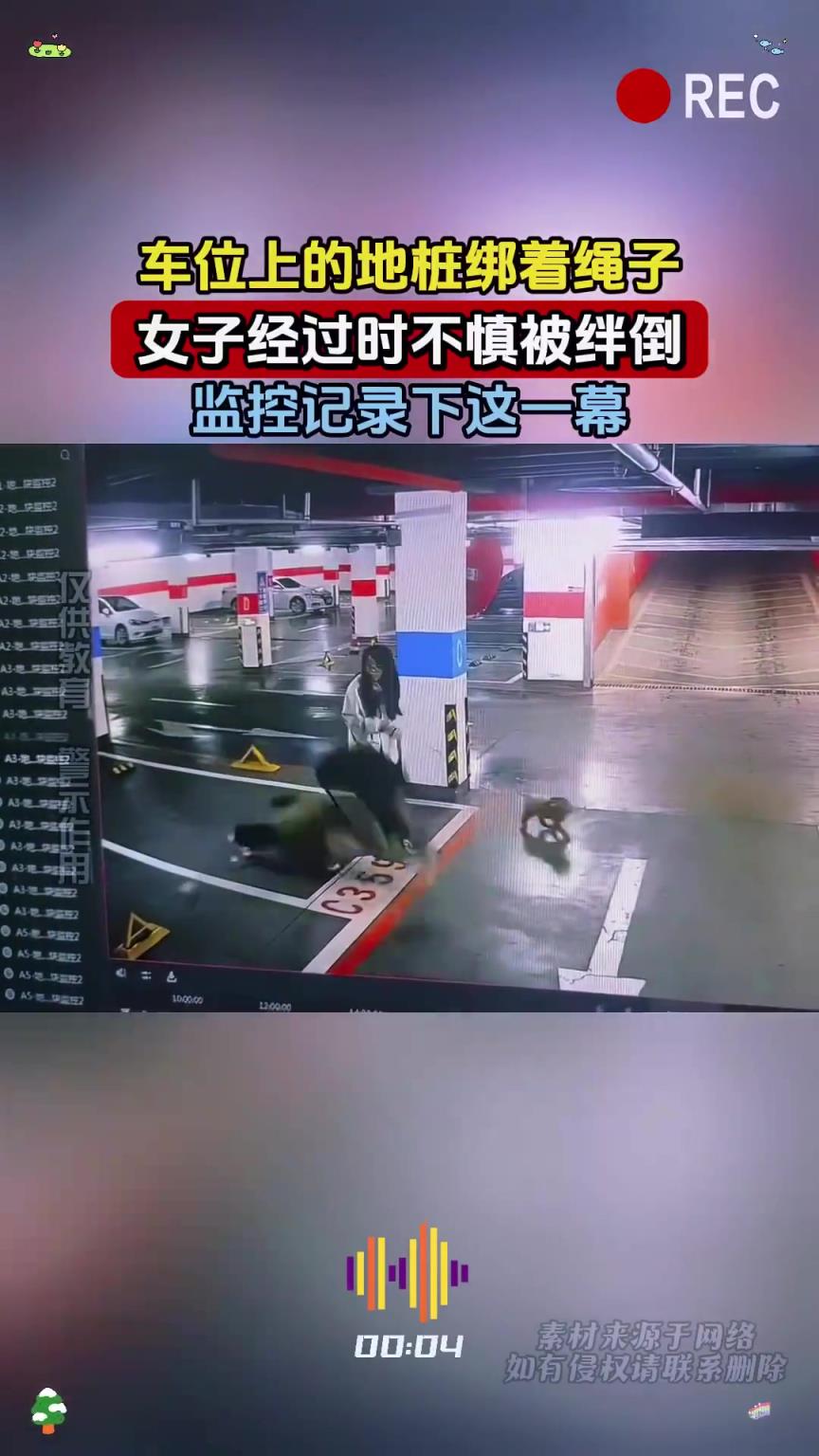 車位上的地樁綁著繩子，女子經(jīng)過時(shí)不慎被絆倒，監(jiān)控記錄下這一幕