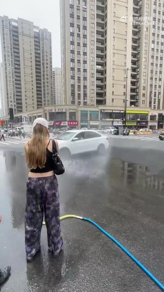 兩個外國姑娘非要玩保安的水管子，結果呲了來車司機一臉