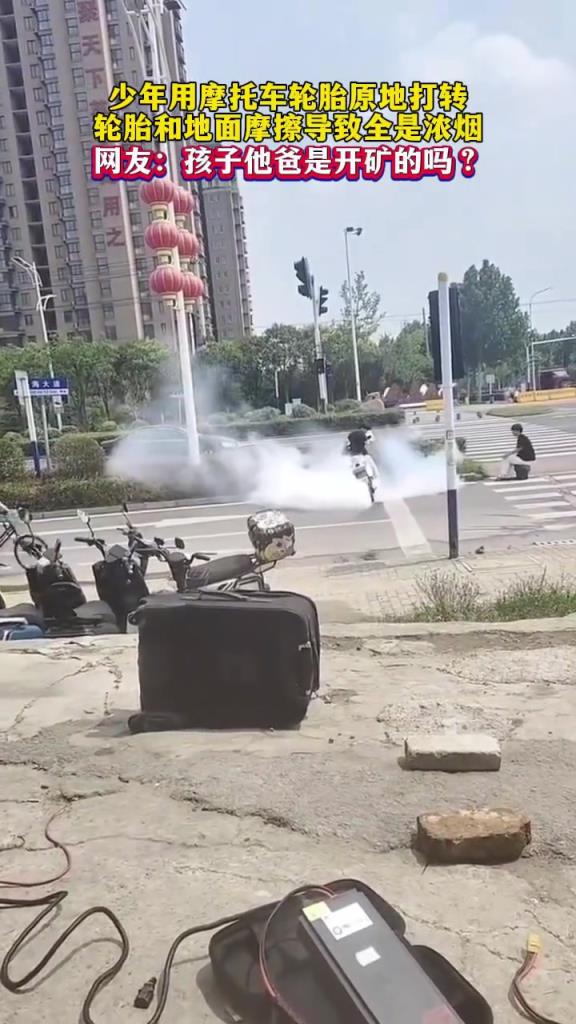 少年用摩托车轮胎原地打转，轮胎和地面摩擦冒出浓烟