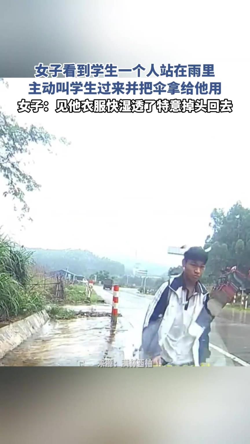 女子看到学生一个人站在雨里，主动叫学生过来并把伞拿给他用