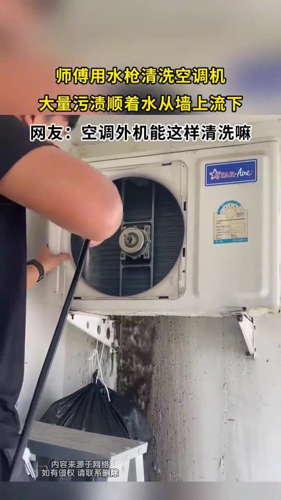 师傅用水枪清洗空调机，大量污渍顺着水从墙上流下！