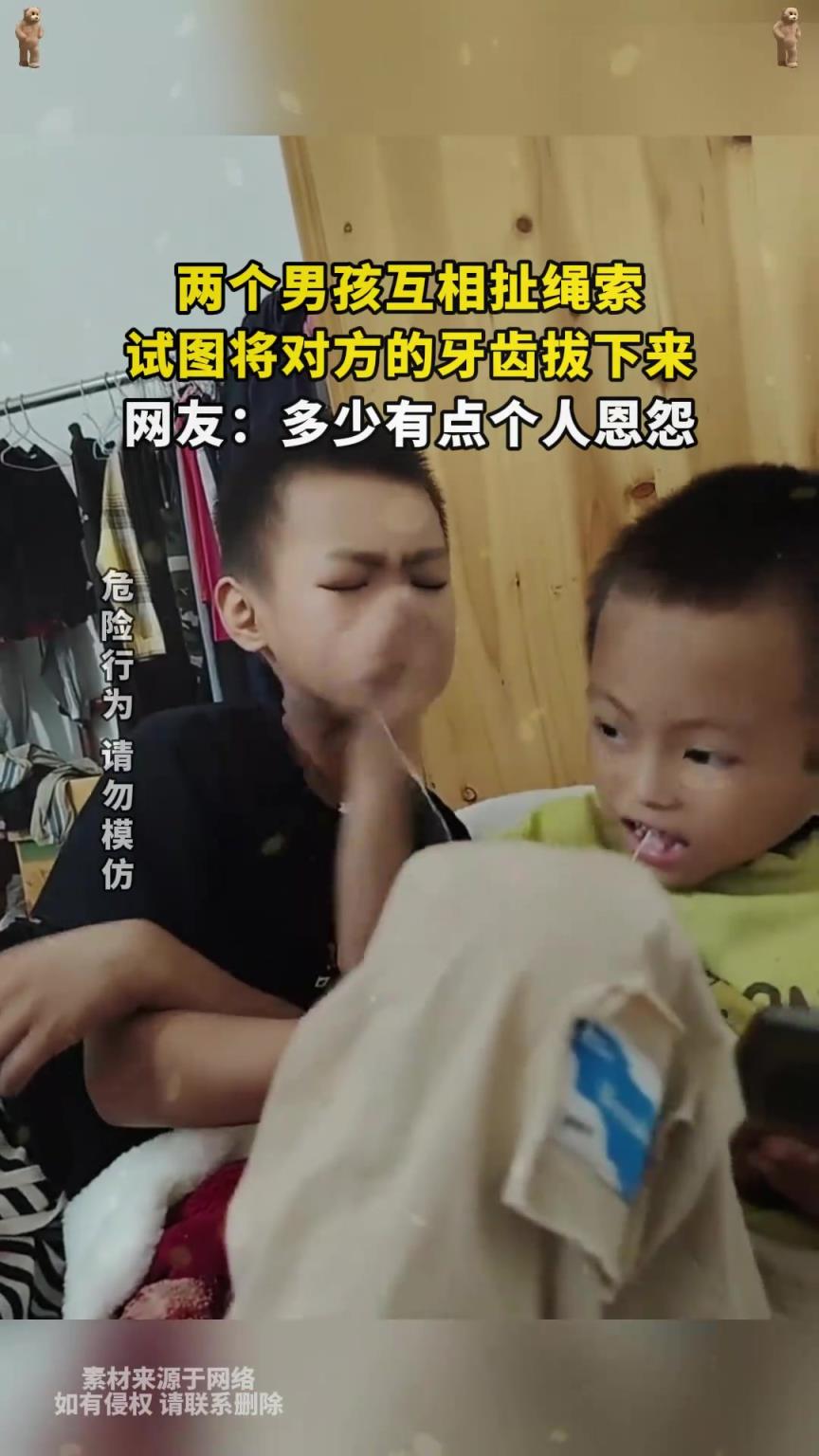 两个男孩互相扯绳子，试图将对方的牙齿拔下来