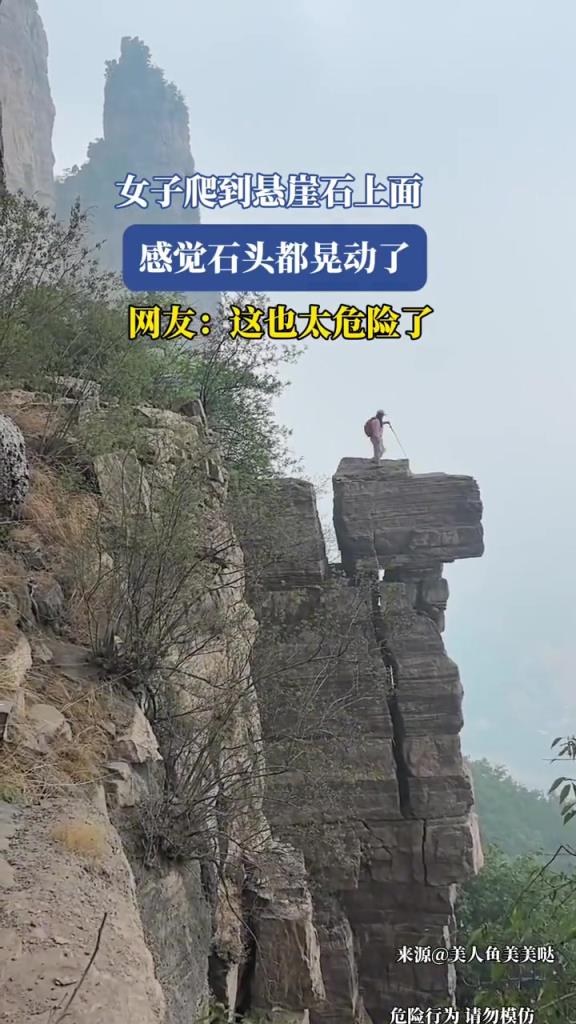 女子爬到懸崖石上面,感覺石頭都晃動了?。? title=