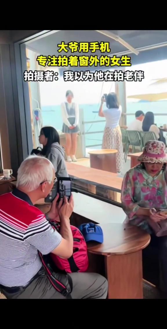 大爷用手机专注拍着窗外的女生,网友:我以为大爷在拍老伴