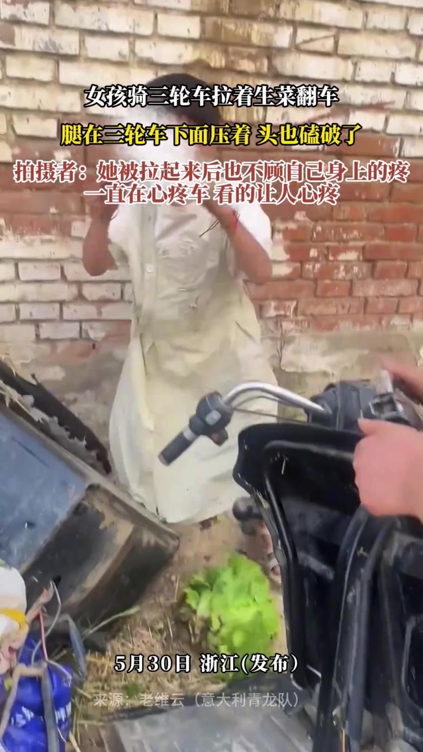 女孩骑三轮车拉着生菜翻车，腿在三轮车下面压着 头也磕破了