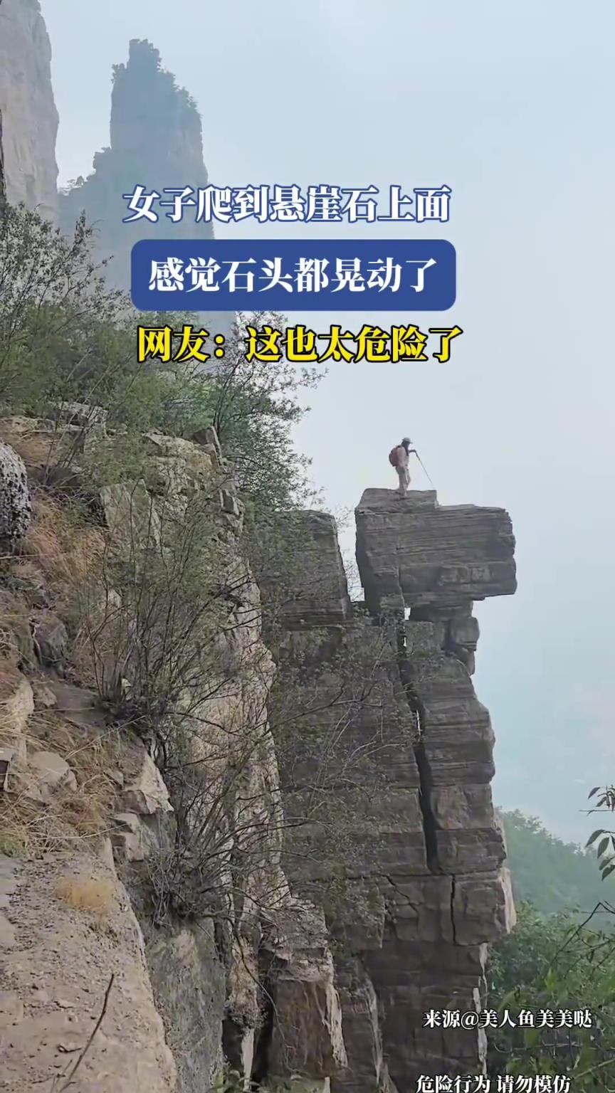 女子爬到悬崖石上面，感觉石头都晃动了！