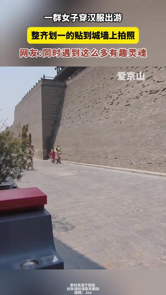 一群女子穿汉服出游，整齐划一的贴到城墙上拍照