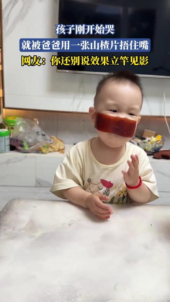 孩子剛開始哭，就被爸爸用一張山楂片捂住嘴