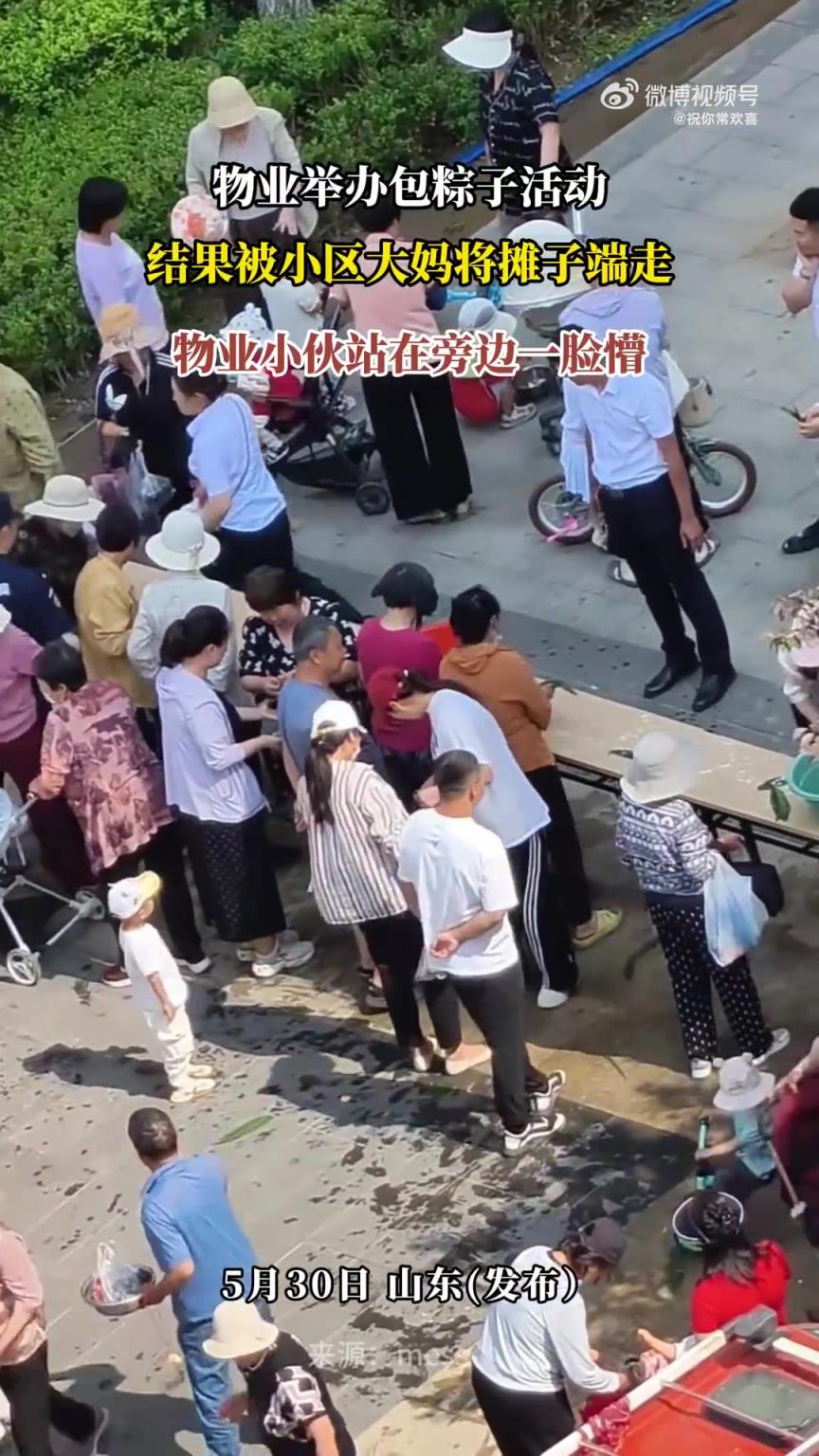 物业举办包粽子活动，小区大妈端走摊子