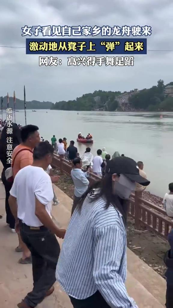 女子看見自己家鄉的龍舟駛來，激動地從凳子上“彈”起來