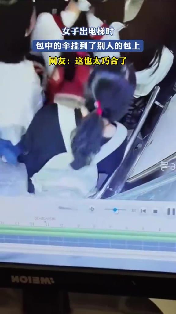 女子出电梯时，包中的伞挂到了别人的包上，网友：这也太巧合了