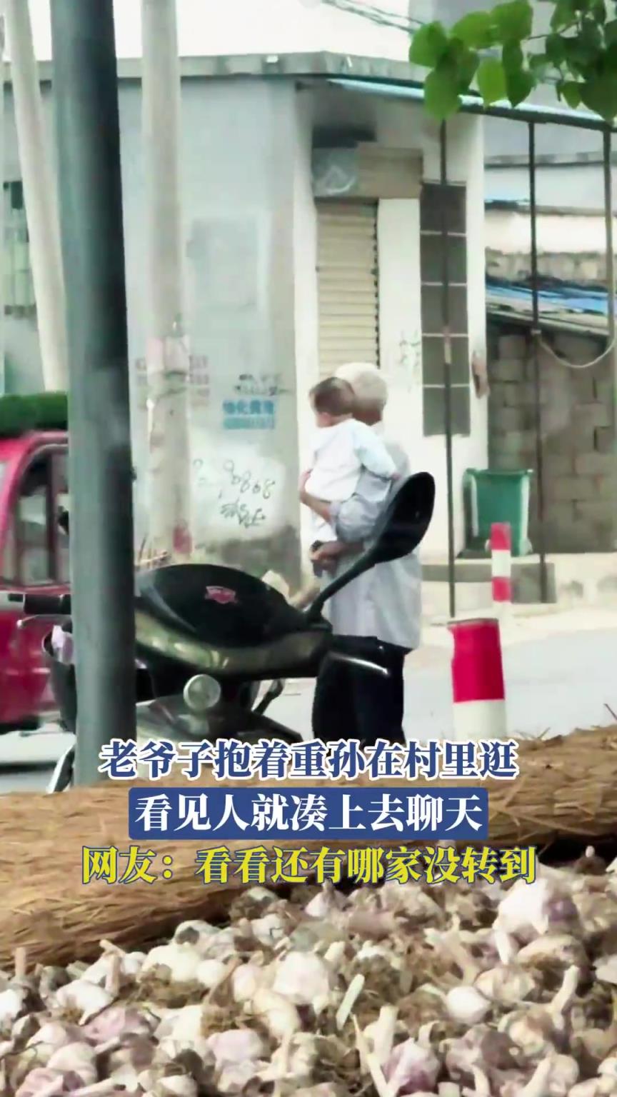 老爷子抱着重孙在村里逛，看见人就凑上去聊天