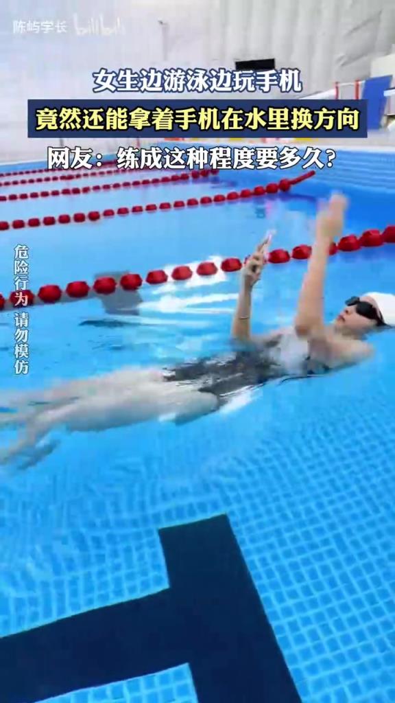 女生邊游泳邊玩手機，竟然還能拿著手機在水里換方向