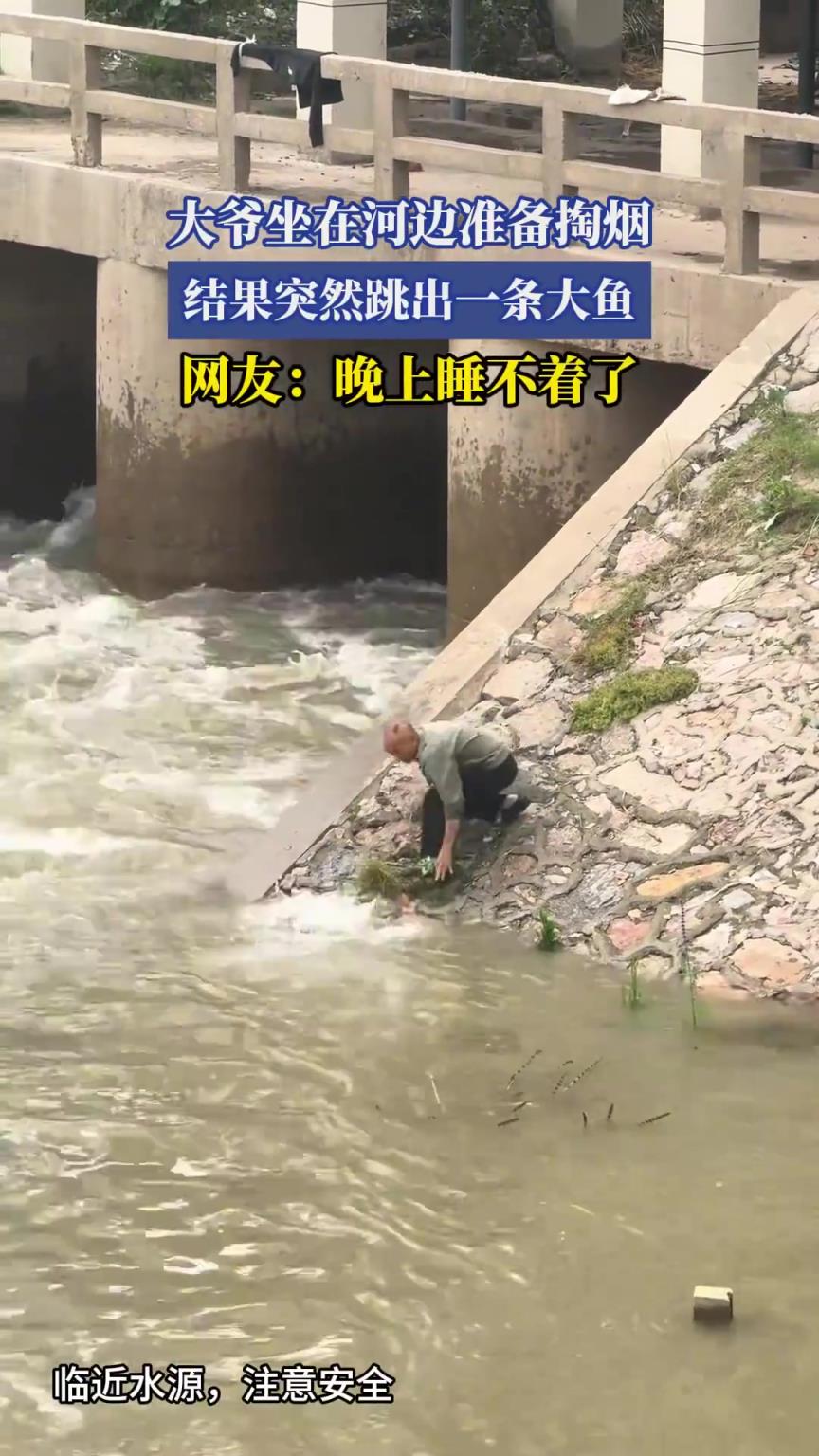 大爺坐在河邊準備掏煙，結(jié)果突然跳出一條大魚