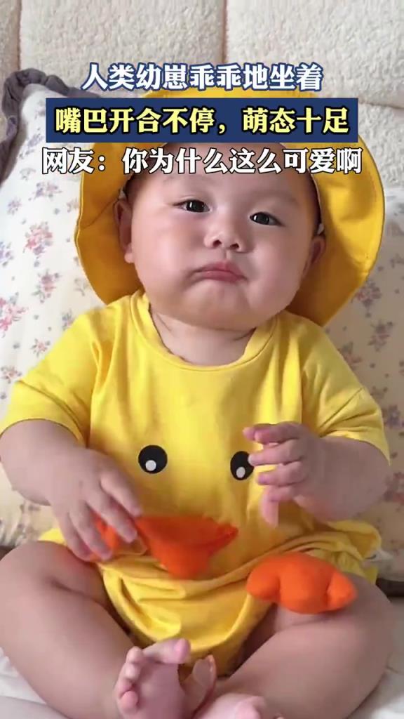 人類幼崽乖乖地坐著，嘴巴開合不停，萌態(tài)十足