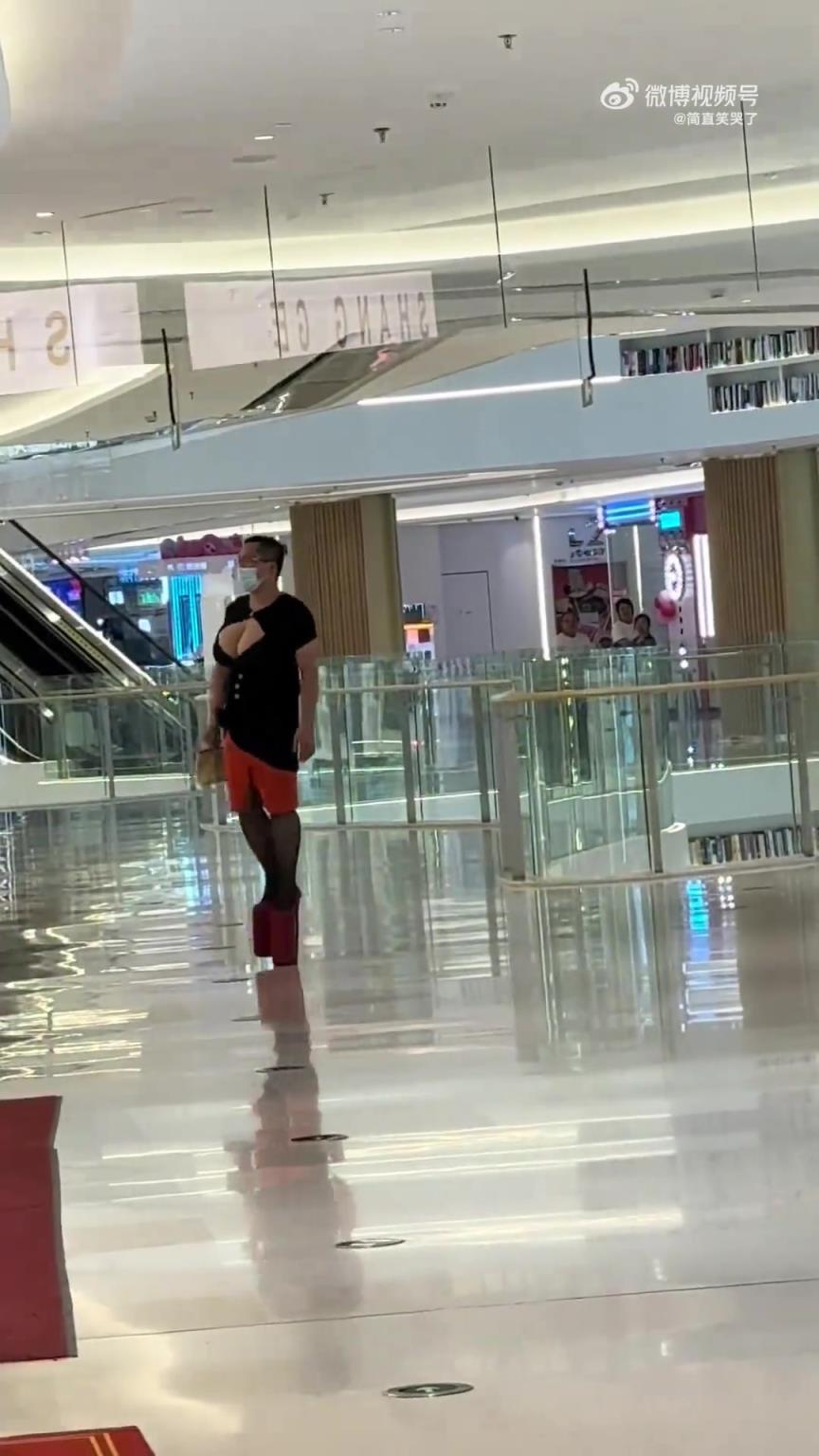 男子身穿女装逛商场，你说他勇敢吧，他还戴口罩...