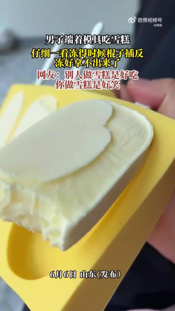 男子端着模具吃雪糕，仔细一看冻得时候棍子插反