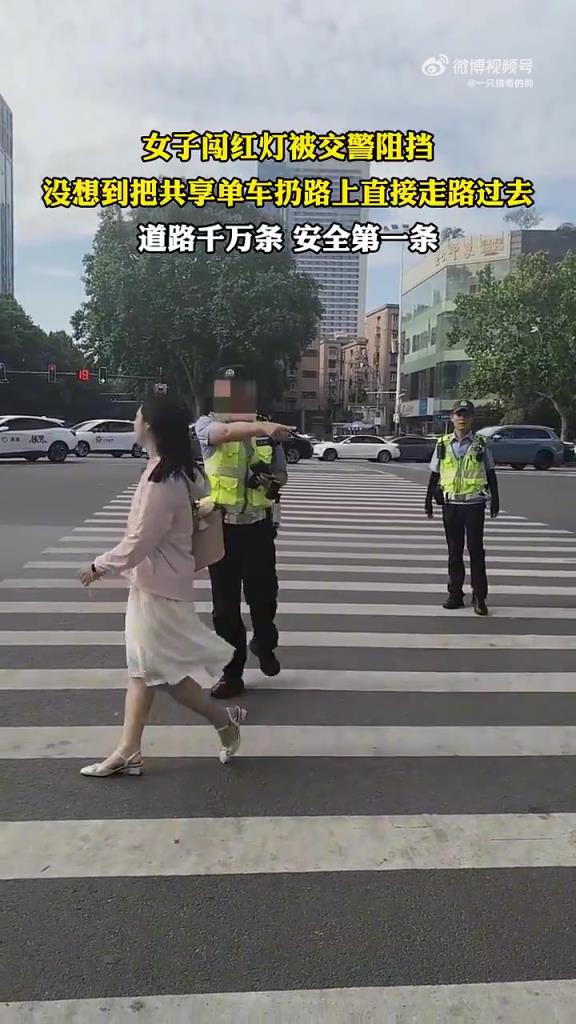 女子闯红灯被交警阻挡 没想到把共享单车扔路上直接走路过去