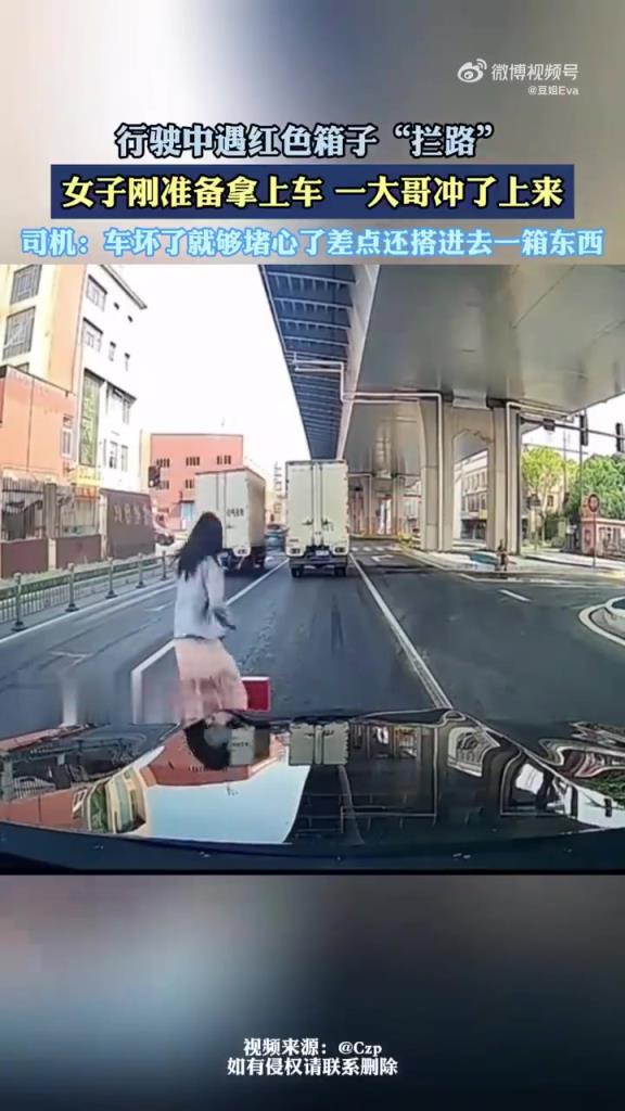 行驶中遇红色箱子拦路 女子刚准备拿上车 一大哥冲了上来