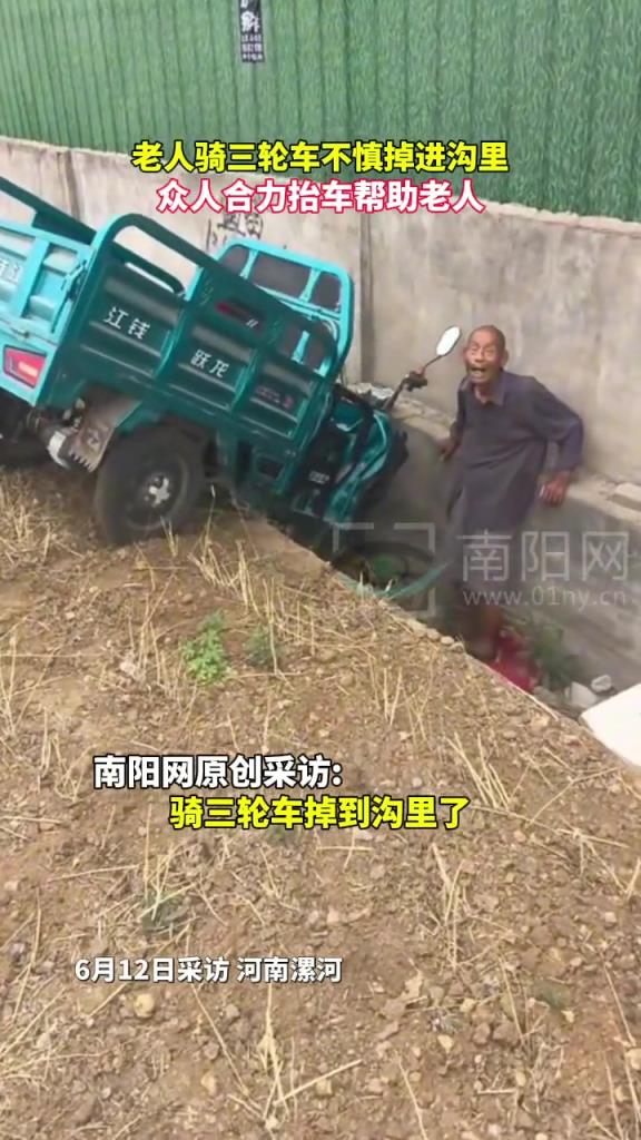 老人骑三轮车不慎掉进沟里，众人合力抬车帮助老人。