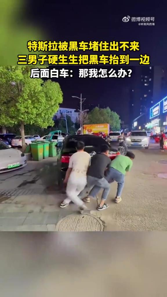 特斯拉被黑车堵住出不来，三男子硬生生把黑车抬到一边