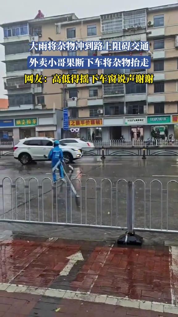 大雨将杂物冲到路上阻碍交通 外卖小哥果断下车将杂物抬走