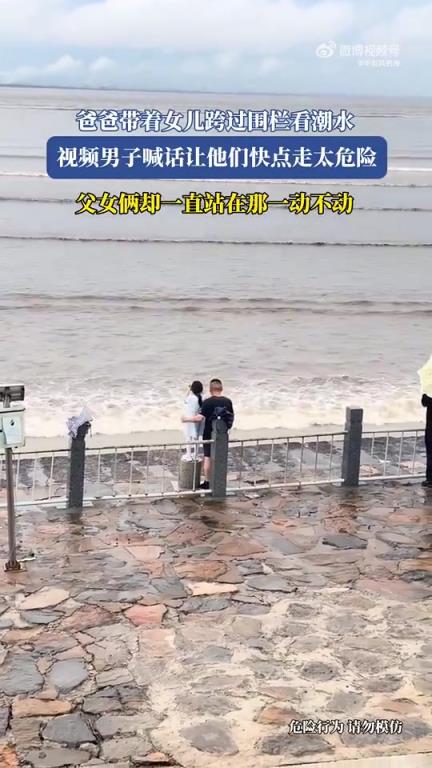 爸爸带着女儿跨过围栏看潮水，视频男子喊话让他们快点走太危险！