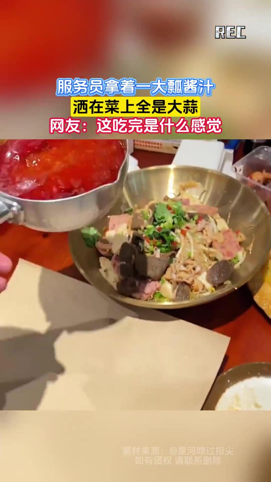 服务员拿着一大瓢酱汁，洒在菜上全是大蒜