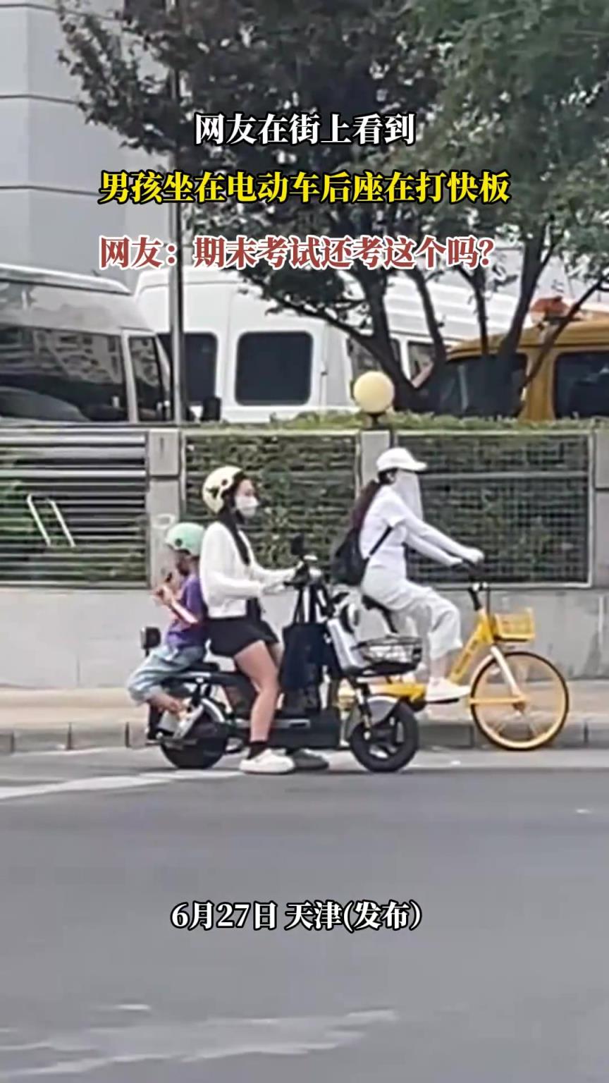 網(wǎng)友在街上看到，男孩坐在電動車后座在打快板