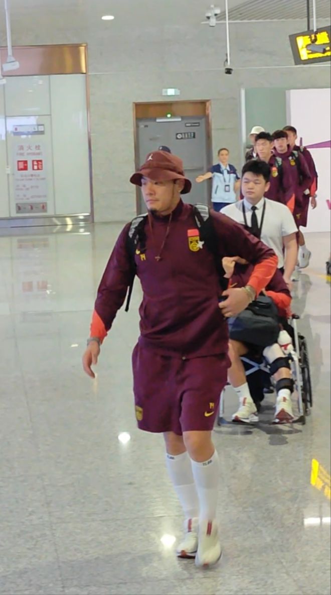 中国男足抵达重庆，百余名球迷接机喊“雄起”